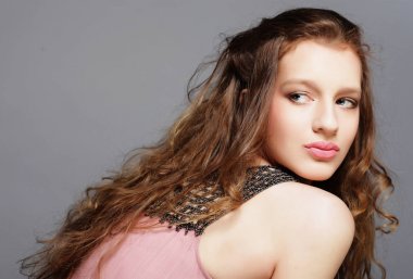 Moda mankeni stüdyoda gri arka planda poz veriyor..