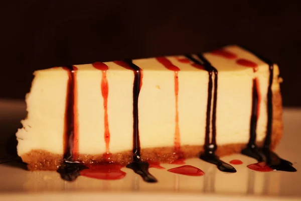 Tarta de queso con salsa de chocolate en un plato blanco —  Fotos de Stock