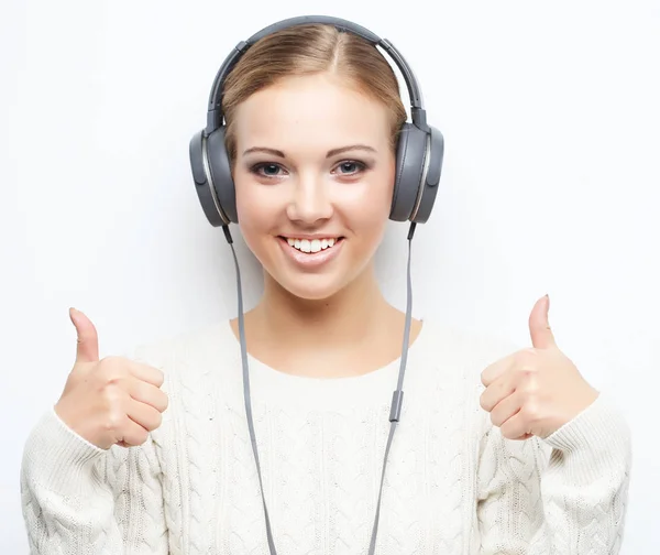 Молодая красивая женщина слушает музыку из наушников — стоковое фото