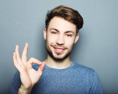 Yakışıklı adam mutlu gülümseme, ok hareket işareti ile elini tut