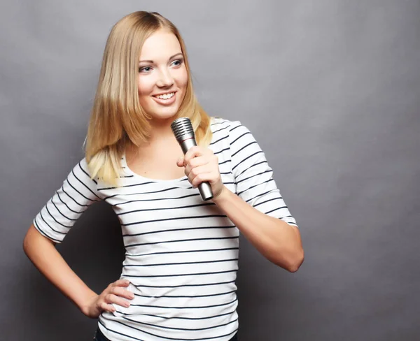 Krása žena nosí tričko s mikrofonem nad šedé pozadí — Stock fotografie