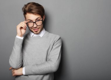 Gülümseyen, stüdyo çekim gözlüklü genç trendy adam