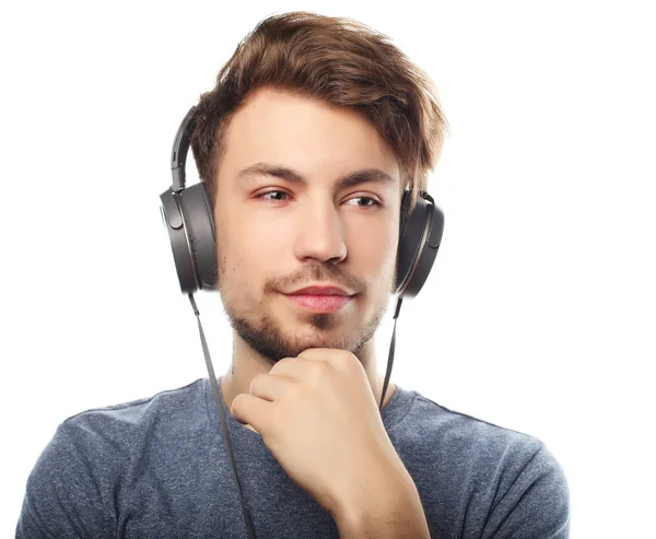 Bonito jovem vestindo fones de ouvido e ouvindo música . — Fotografia de Stock