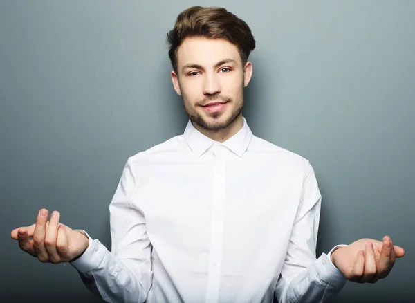 Giovane uomo d'affari felice sorridente mostra qualcosa — Foto Stock