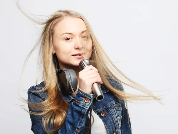 Ung jente med mikrofon synger – stockfoto