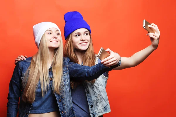 Dos amigas adolescentes en traje hipster hacen selfie en un pho — Foto de Stock