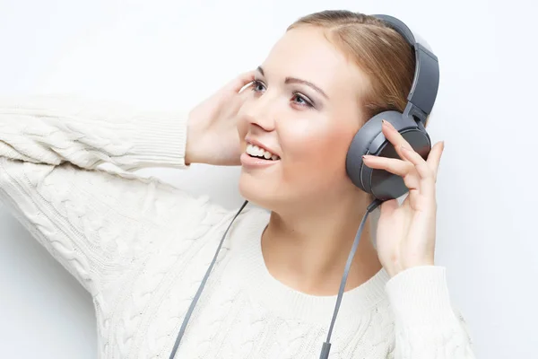 Молодая красивая женщина слушает музыку из наушников — стоковое фото