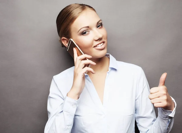 Retrato de una mujer de negocios sonriente hablando por teléfono y mostrando OK — Foto de Stock