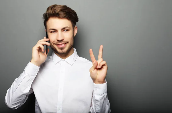 Happy young business man in shirt  gesturing and smiling while t — Stock Photo, Image