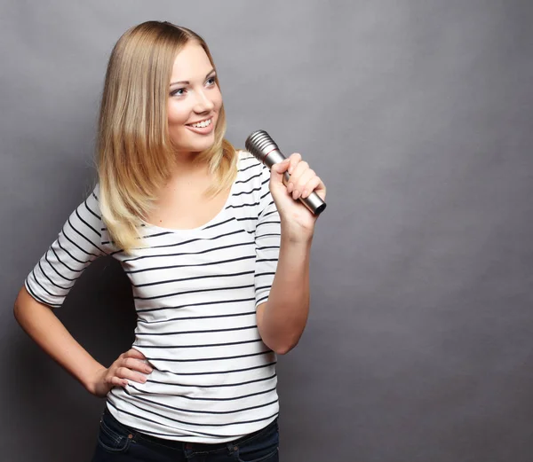 Γυναίκα ομορφιά φορώντας μπλουζάκι με μικρόφωνο πάνω από την γκρίζα έκφραση — Φωτογραφία Αρχείου