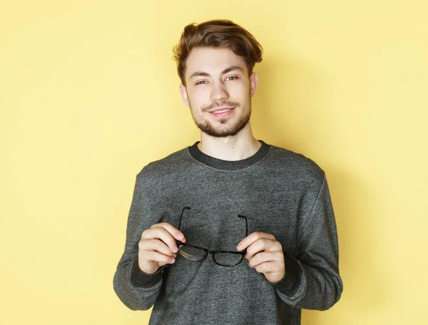 Giovane uomo di tendenza con gli occhiali sorridente, girato in studio — Foto Stock