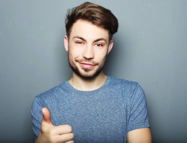 Yakışıklı adam mutlu gülümseme, ok hareket işareti ile elini tut