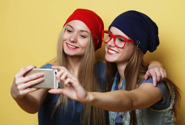 Gelukkig meisjes met smartphone op gele achtergrond. Gelukkig zelf — Stockfoto