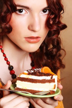 güzel bir kek olan kıvırcık kadın gülümseyerek