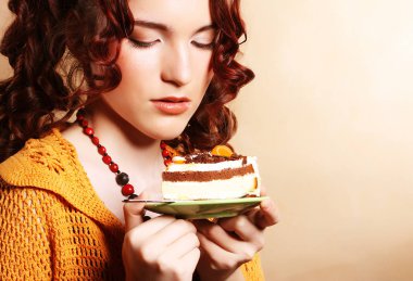 güzel bir kek olan kıvırcık kadın gülümseyerek