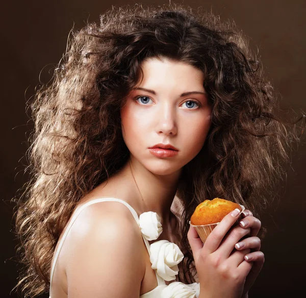 Jeune femme bouclée avec un gâteau — Photo