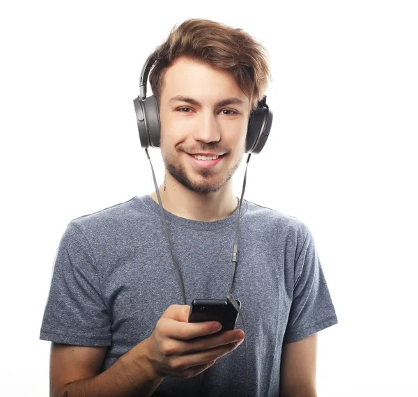 Hombre sosteniendo el teléfono móvil y lamiendo a la música sobre respaldo blanco — Foto de Stock
