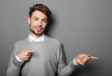 Genç ve yakışıklı bir işadamı parmağıyla işaret ediyor.