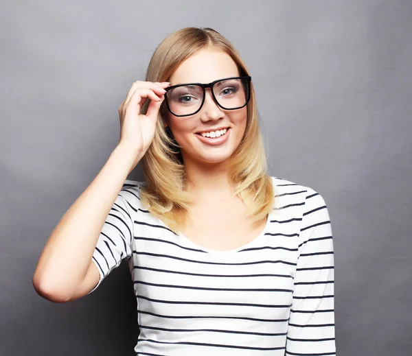 Casual jongedame stijl over grijze achtergrond, studio portret. — Stockfoto