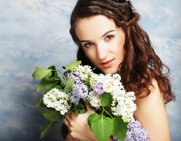 Jovem mulher bonita com flores lilás — Fotografia de Stock