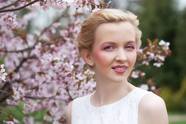 Krásná mladá žena v jarní zahradě — Stock fotografie