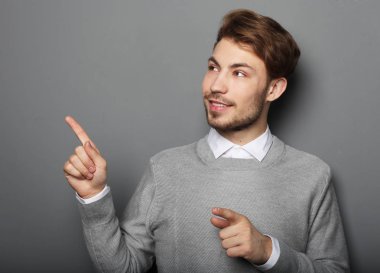 Genç ve yakışıklı bir işadamı parmağıyla işaret ediyor.