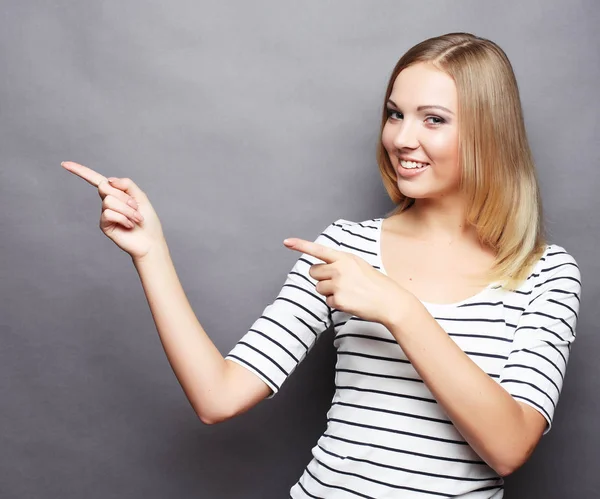 Cheerful young woman showing copyspace, visual imaginary or some — Stock Photo, Image