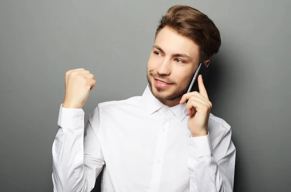 Happy young business man in shirt  gesturing and smiling while t — Stock Photo, Image