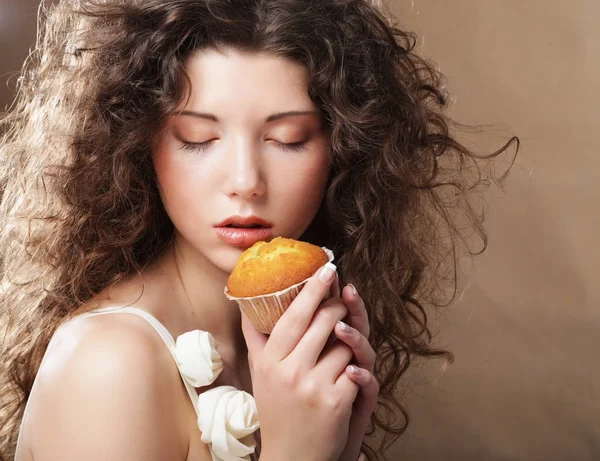 Jeune femme bouclée avec un gâteau — Photo