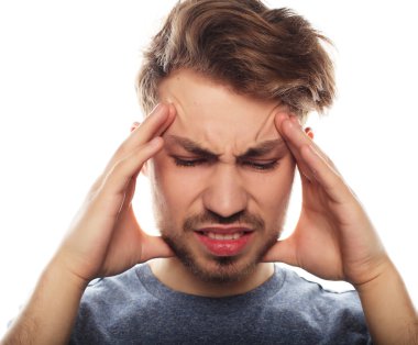 Genç iş adamı kafasına dokunuyor ve gözlerini kapalı tutuyor.