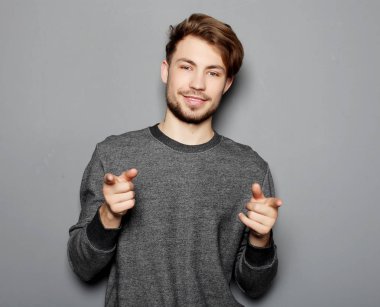 Genç ve yakışıklı bir işadamı parmağıyla işaret ediyor.