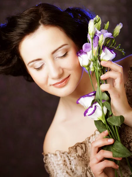 Mooie brunette vrouw met lila bloemen — Stockfoto