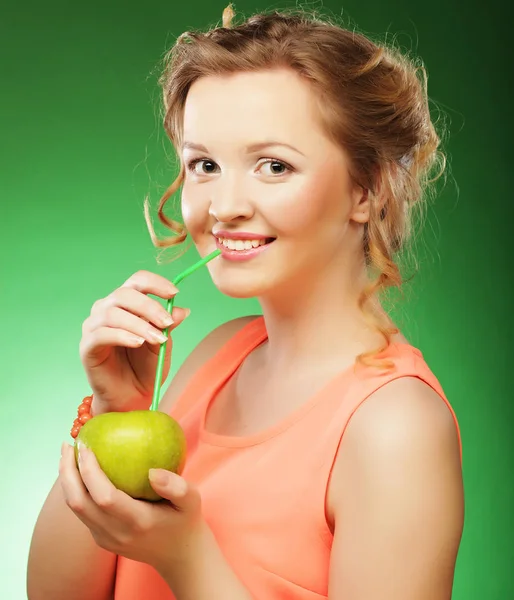 Lycklig kvinna med äpple och Cocktail strån, grön bakgrund — Stockfoto