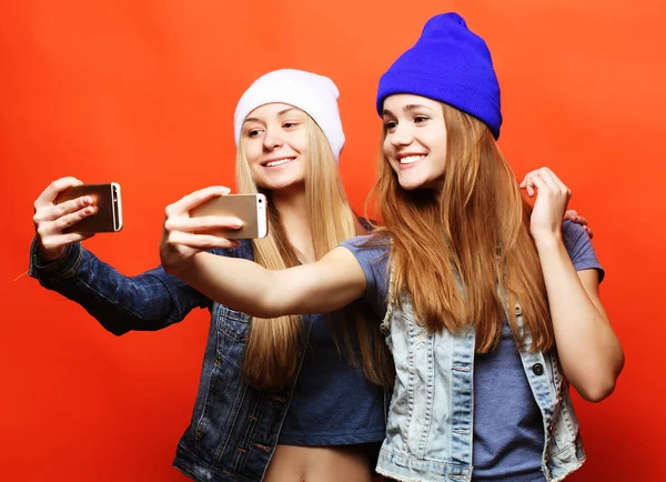 Dvě dospívající dívky přátelé v hipster oblečení, aby selfie na telefonu — Stock fotografie
