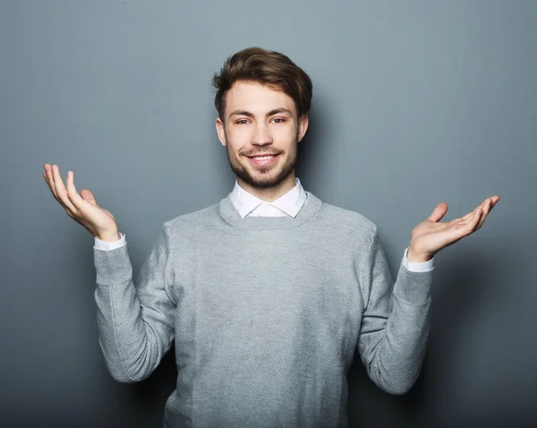 Young smiling happy business man shows something — Stock Photo, Image