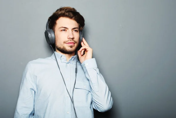 Schöner junger Mann trägt Kopfhörer und hört Musik. — Stockfoto