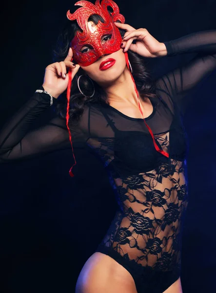 Jong sexy striptease danser met masker over donkere achtergrond — Stockfoto