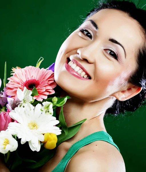 Mujer asiática joven con flores de ramo sobre fondo verde — Foto de Stock