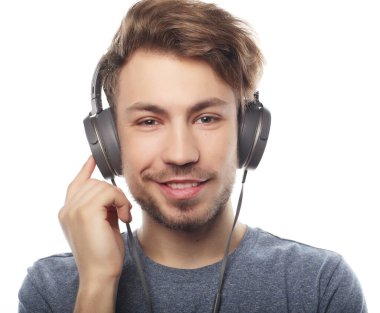 Kulaklık takıp müzik dinleyen yakışıklı bir genç..