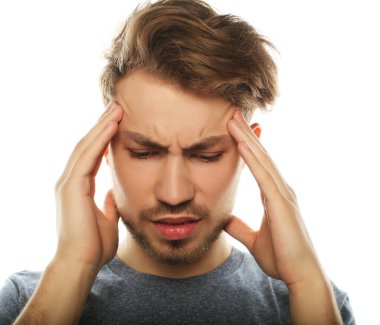 Genç iş adamı kafasına dokunuyor ve gözlerini kapalı tutuyor.