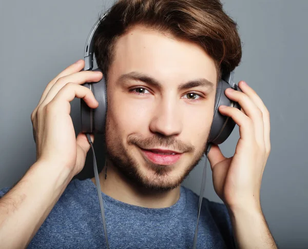 Schöner junger Mann trägt Kopfhörer und hört Musik. — Stockfoto