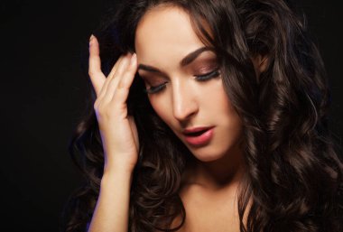 Genç esmer kadın, uzun siyah kıvırcık saçlı.