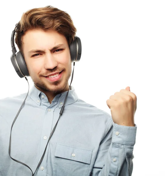 Bonito jovem vestindo fones de ouvido e ouvindo música . — Fotografia de Stock