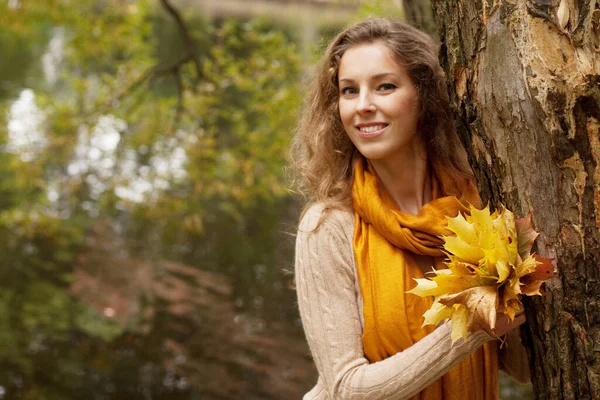 Giovane donna sorridente nel parco autunnale, da vicino — Foto Stock