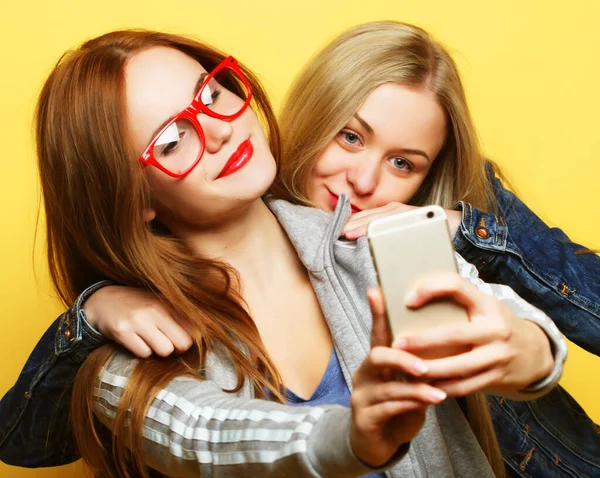 Hippi kıyafetli iki genç kız telefonda selfie çekiyor. — Stok fotoğraf