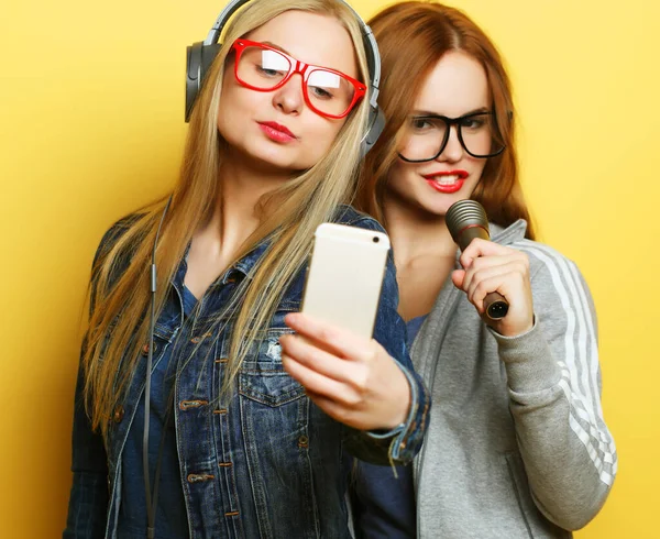 Dwie dziewczyny z mikrofonem śpiewając i bawiąc się razem, zrobić selfie — Zdjęcie stockowe