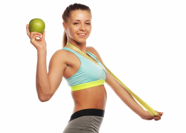 Mladá veselá žena ve sportovním oblečení s jablkem přes bílé pozadí — Stock fotografie