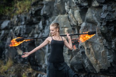 Alevli meşalelerle siyah elbiseli kız .