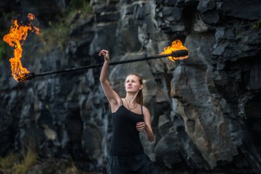 Alevli meşalelerle siyah elbiseli kız .