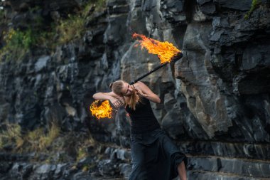 Alevli meşalelerle siyah elbiseli kız .